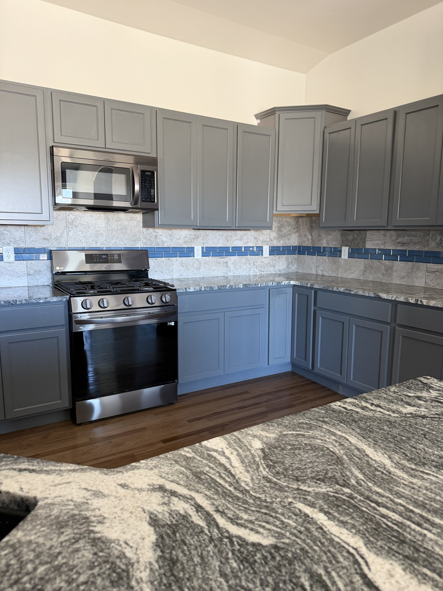 Clean kitchen with finished cabinets, appliances, counters, and floors